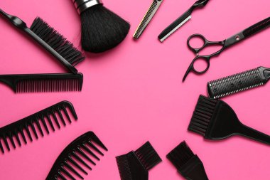 Farklı kuaför aletlerinin çerçevesi pembe arka planda, düz yerde. Metin için boşluk