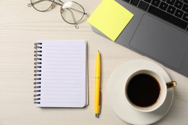 Not defteri, kalem, yapışkan not, bardaklar, kahve ve dizüstü bilgisayar ahşap masa, düz uzanma