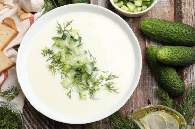 Lezzetli salatalık çorbası kasede ve ahşap masada malzemeler.