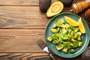 Lezzetli avokado roka, limon ve ahşap masa üzerine sos, düz yatak. Metin için boşluk