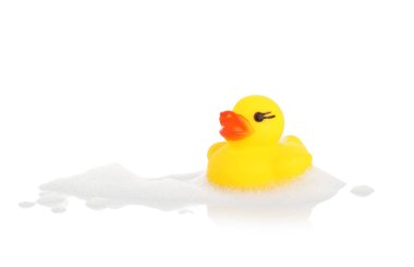 Aynada beyaz arka planda sevimli bir lastik ördek ve köpük.