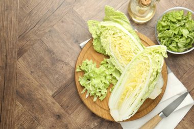 Taze kesilmiş Çin lahanası, ahşap masa üzerinde yağ ve bıçak, düz. Metin için boşluk