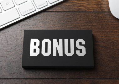 Siyah bonus kart ve bilgisayar klavyesi ahşap masa, üst görünüm
