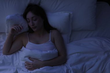 Evdeki yatakta uyuyan güzel bir kadın.