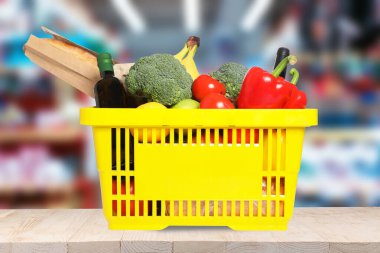 Süpermarketteki ahşap masada içi alışveriş sepetleriyle dolu.