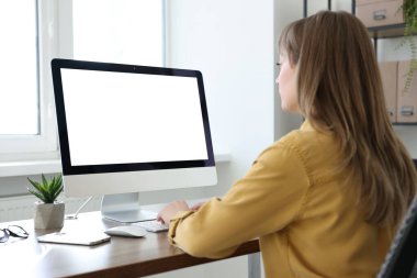 Ofisteki ahşap masada çalışan bir kadın. Tasarım için model