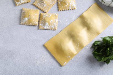 Pişmemiş ravioli ve maydanoz ışık masasında, düz yerde. Metin için boşluk