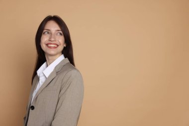 Bej arka planda takım elbiseli mutlu kadın, mesaj için boşluk