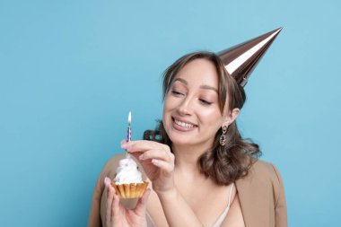 Doğum günü kutlaması. Açık mavi arka planda keki olan kadın. Metin için boşluk