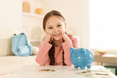 İçerideki masada cep harçlığı olan bir kız.