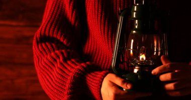 Adam gaz lambasını ahşap arka plana çeviriyor, yakın plan.