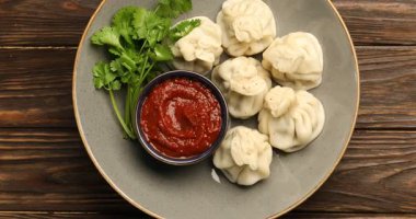 Baharatlı, soslu, ahşap masada kişniş soslu lezzetli hinkali, dönüyor. Üst görünüm