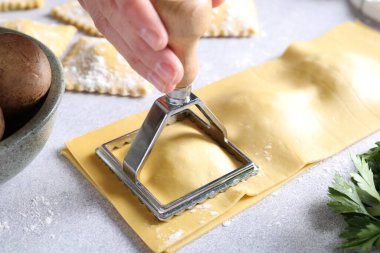 Işık masasında ravioli kesen kadın, yakın plan.