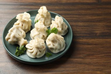 Ahşap masada kişniş soslu nefis hinkali, yakın plan. Metin için boşluk