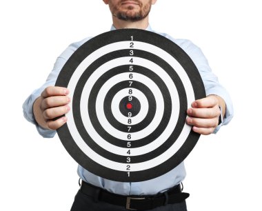 Hedef alınıyor. Beyaz arka planda dart tahtası olan adam, yakın plan.