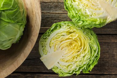 Tahta masanın üzerinde taze lahana yarımları, düz uzanmış.