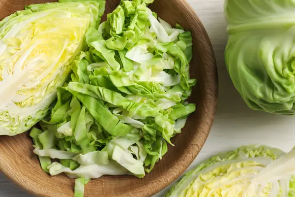 Taze yeşil lahanalar açık ahşap masada, düz yatıyordu.