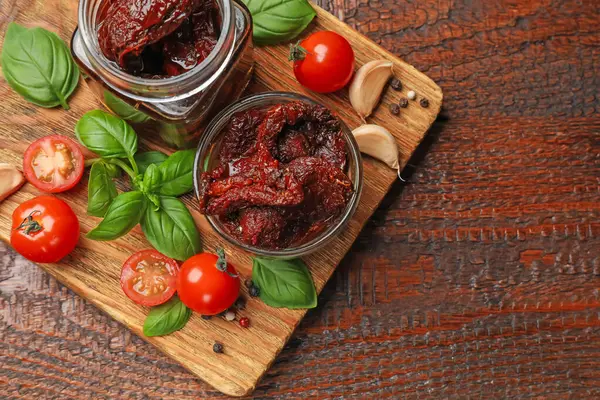 Lezzetli, kurutulmuş domatesler, taze sebzeler, fesleğen ve sarımsak ahşap masa, üst manzara