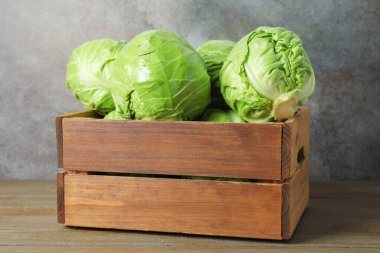 Ahşap masada taze lahana ve sandık.