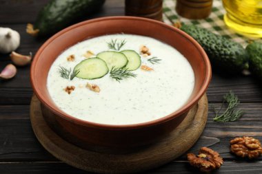 Dereotlu salatalık çorbası, ceviz ve ahşap masa malzemeleri, yakın plan.