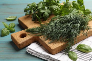 Mavi ahşap masada farklı taze otlar, yakın plan.