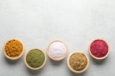 Açık gri masadaki farklı süper yiyecek tozları, düz yatıyordu. Metin için boşluk