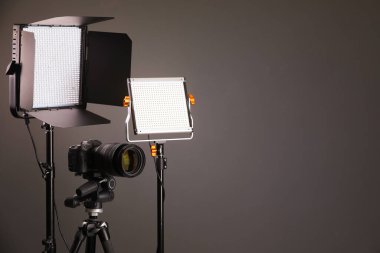 Profesyonel ışıklandırma ekipmanı ve gri arka planda kamera. Metin için boşluk