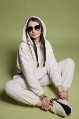 Yeşil arka planda şık giyinmiş güzel bir kadının moda portresi.