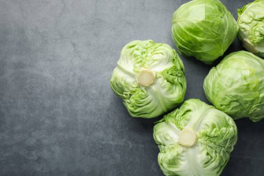 Taze yeşil lahanalar gri masada, düz yerde. Metin için boşluk