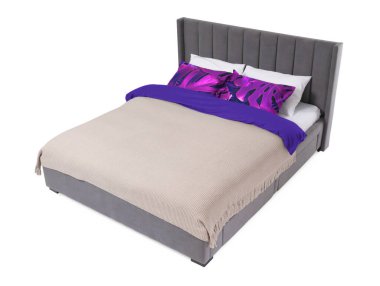 Beyaz arka planda güzel çarşaflarla yapılmış bir yatak. Çiçek desenli kumaş