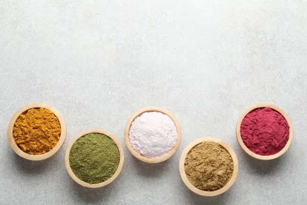 Açık gri masadaki farklı süper yiyecek tozları, düz yatıyordu. Metin için boşluk