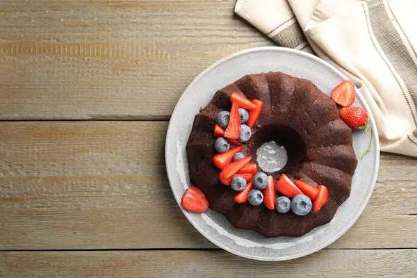 Tahta masanın üstünde böğürtlenli çikolatalı kek, üst manzara. Metin için boşluk