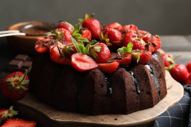 Çilekli, naneli ve çikolatalı nefis kek. Masanın üzerinde gri arka plan, yakın plan.