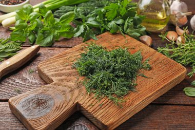 Farklı taze otlar ve baharatlar ahşap masada, yakın plan.