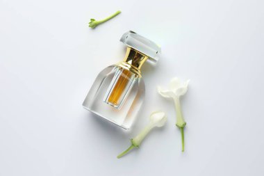 Beyaz arka planda parfüm ve yasemin çiçekleri, düz yatıyordu.