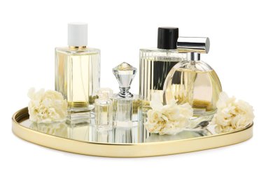 Birçok farklı parfüm şişeleri ve çiçekler beyaz üzerine izole edilmiş.