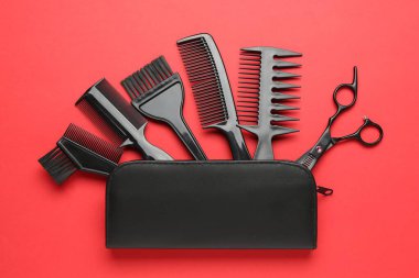 Farklı kuaför aletleri ve kırmızı arka planda çanta, düz yatıyordu