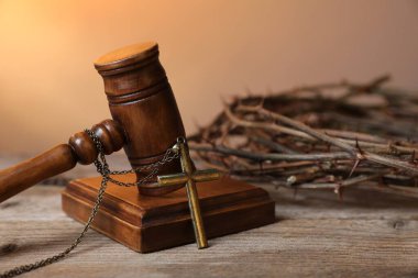 Ahşap masa üzerinde haç ve dikenli taç ile hakim tokmağı, yakın çekim