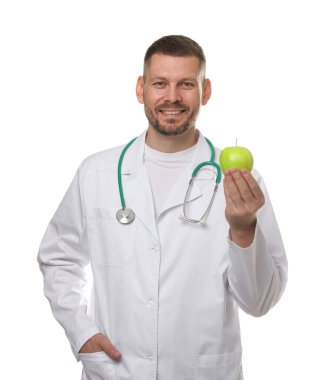 Beyaz arka planda yeşil elmalı ve steteskoplu beslenme uzmanı.