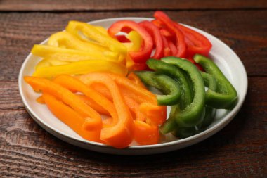 Ahşap masada renkli dolmalık biberler kes, yakın plan.