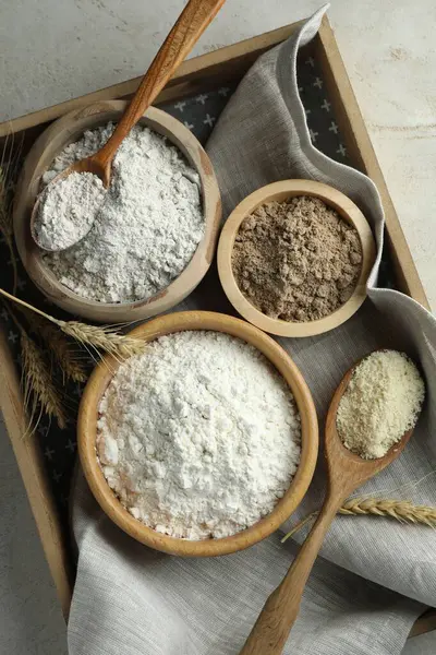 Açık gri masa üzerinde farklı un türleri, üst görünüm