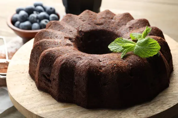 Naneli çikolatalı kek ve ahşap masada yaban mersini, yakın plan.