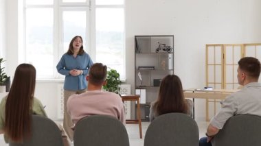 Akıl hocası ve grup insan içeride yaşam koçluğu dersinde toplantı yapıyorlar.