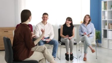 Yaşam koçluğu dersinde kapalı alanda toplantı yapan bir grup insan.