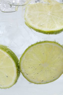 Kola suyunu limon dilimleri ve beyaz arka planda buzla tazeliyorum. Yakın plan.