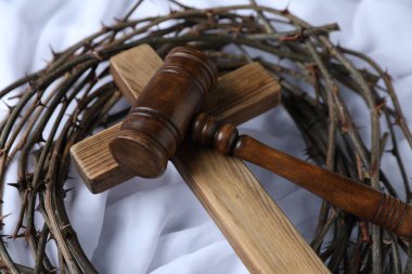 Yargıç tokmağı, dikenli taç ve beyaz kumaşta ahşap haç, yakın plan.