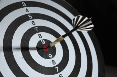Hedef alınıyor. Siyah arkaplanda ok olan dart tahtası, yakın plan