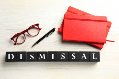 Siyah küplerden, kalemden, gözlüklerden ve beyaz ahşap zemin üzerine not defterlerinden oluşan kelime kovulması, üst görünüm