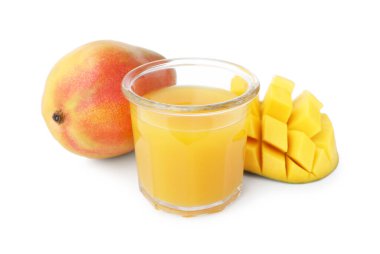 Bardaktaki lezzetli mango suyu ve beyaz üzerine izole edilmiş taze meyveler.