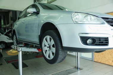 Araba servisinde lastik değiştirirken otomobili kaldırmış.